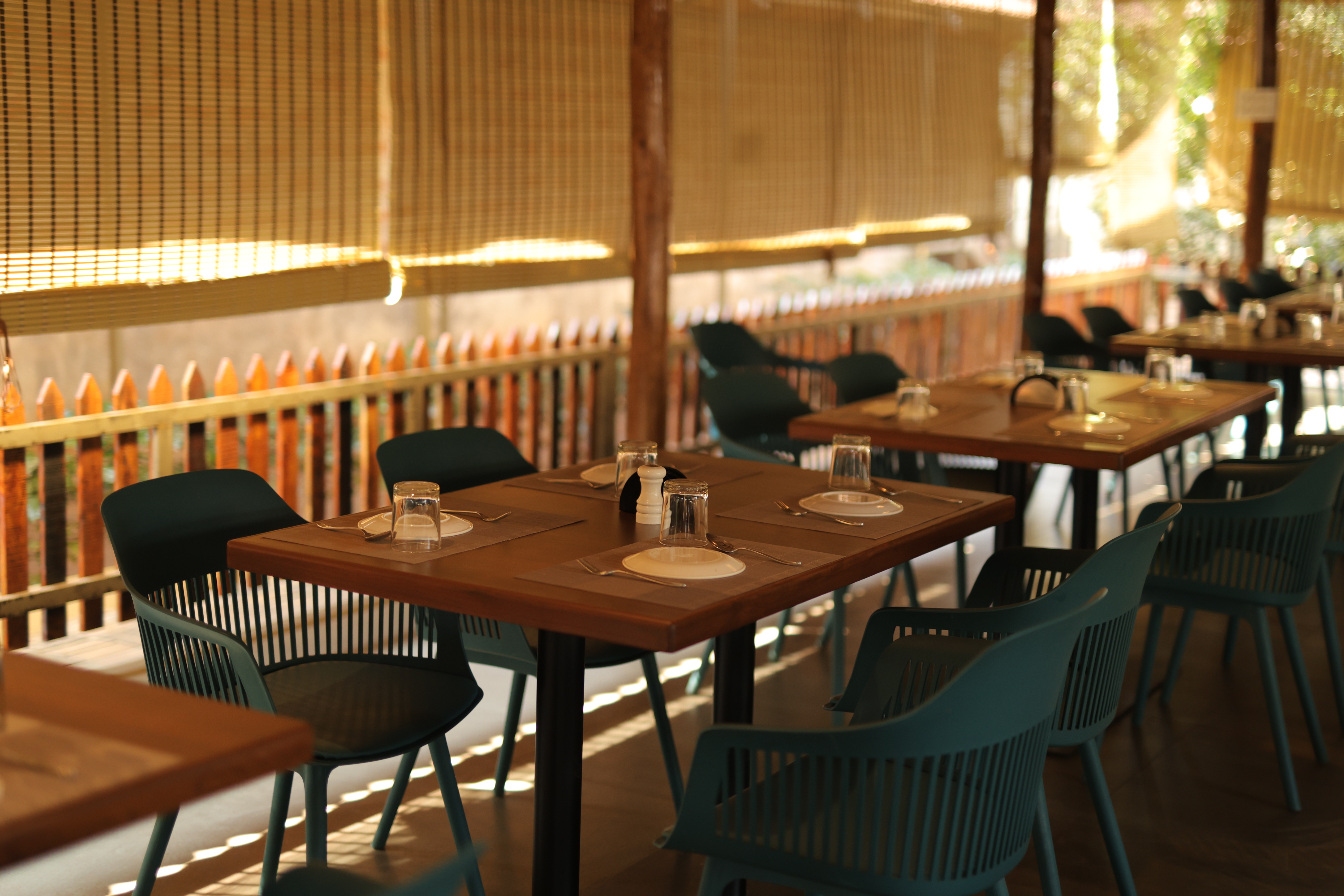 Outdoor garden dining area with teal chairs at Jatra Countryside