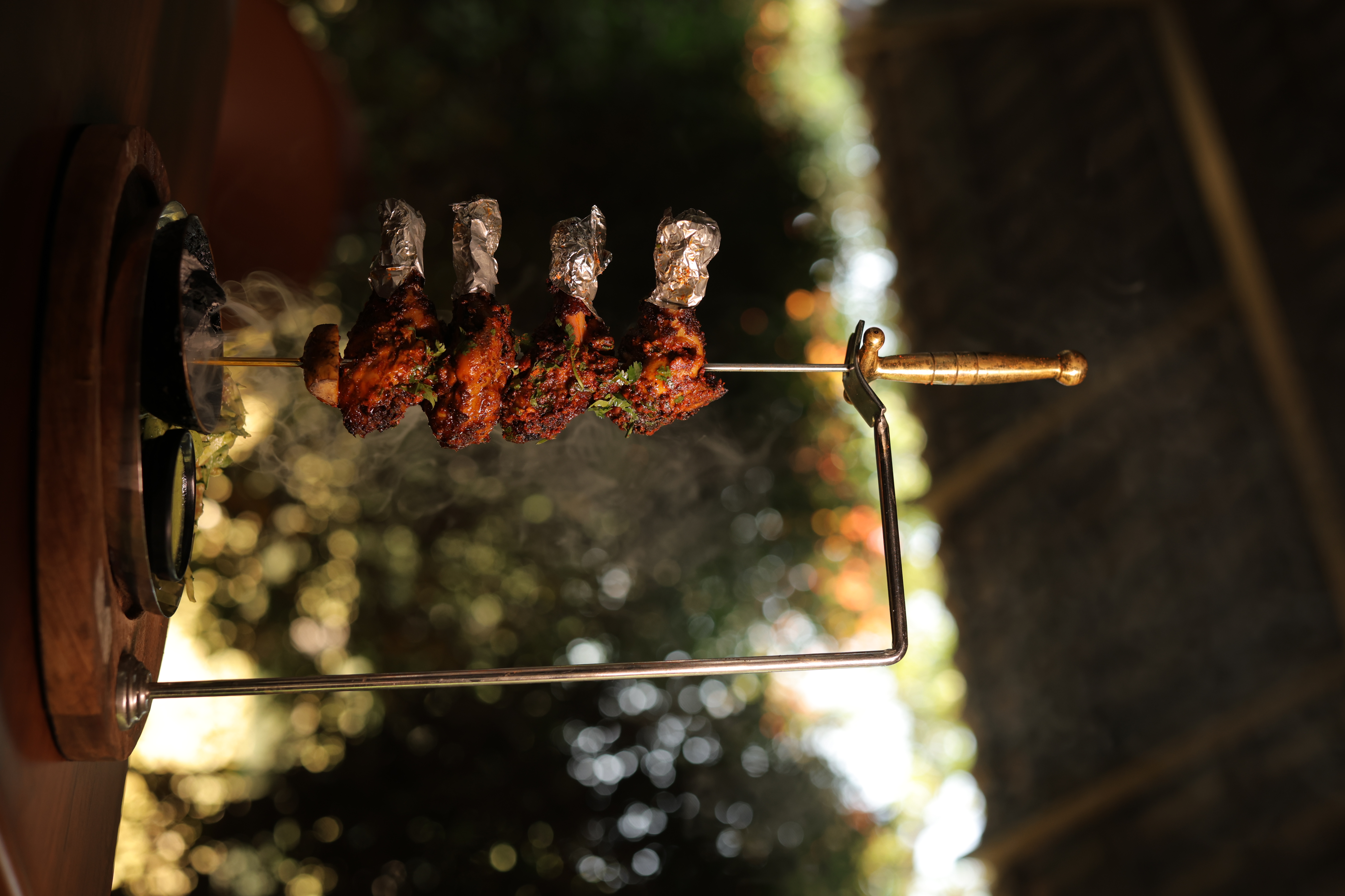 Tandoori chicken on a rotating golden skewer at Jatra Countryside